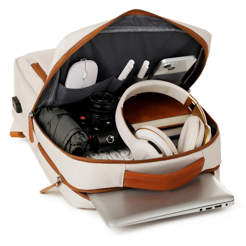 Open backpack with laptop, camera, and other items on a white background