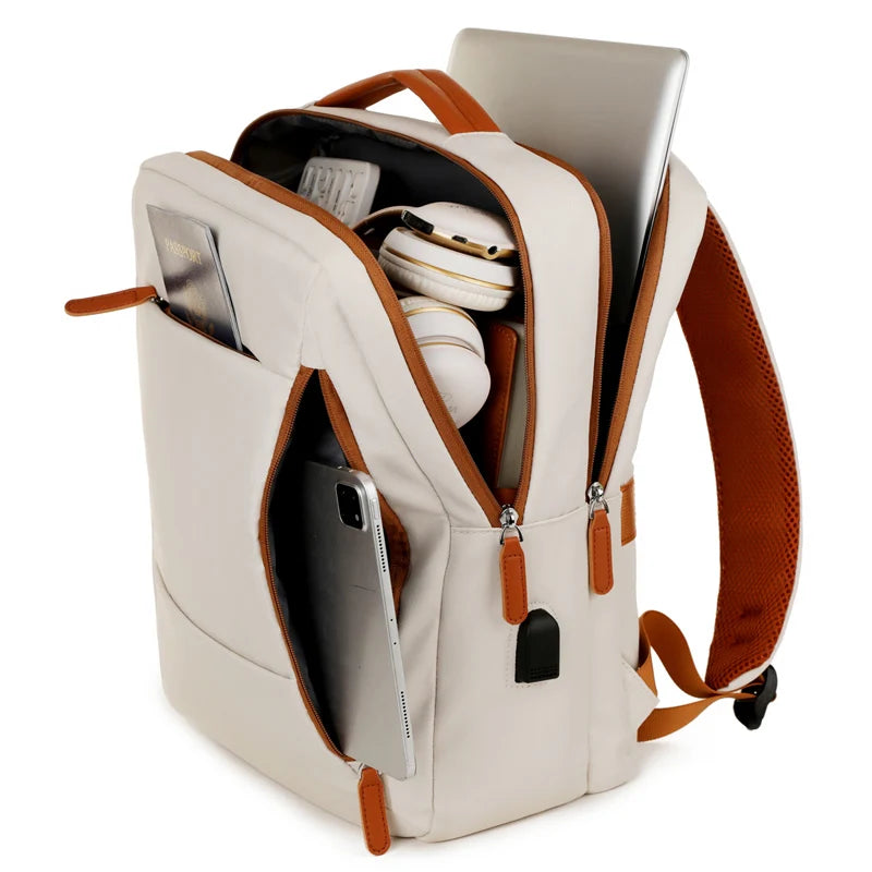 Beige backpack with brown straps containing a laptop, phone, and headphones on a white background