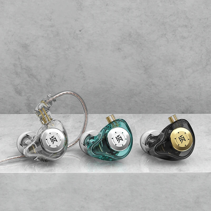 Three in-ear monitors on a gray surface with a concrete wall background