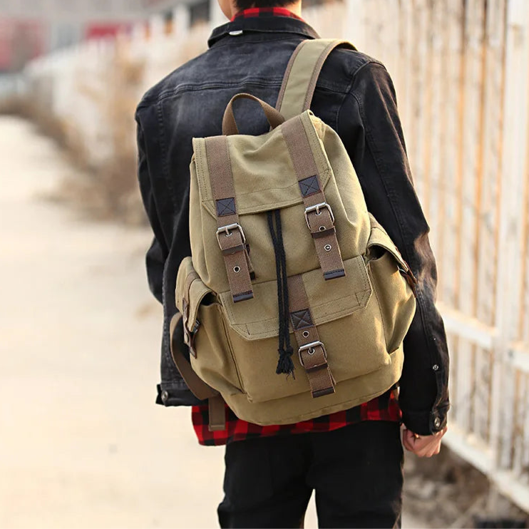 Person wearing a beige backpack walking on a path with a blurred background