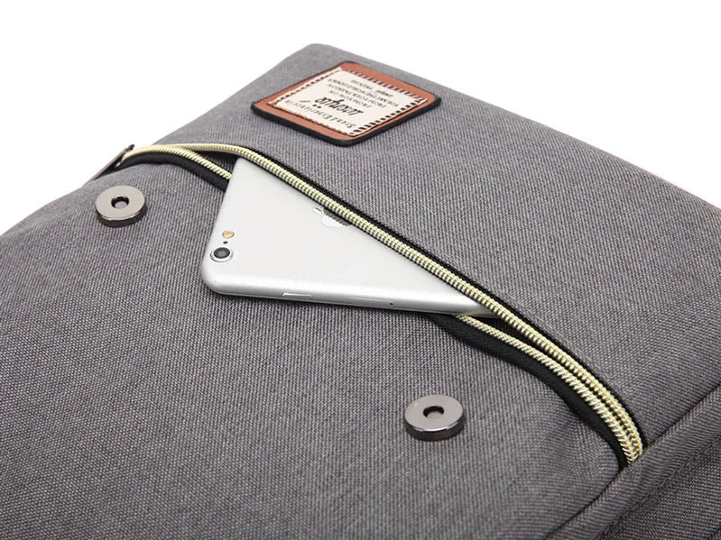 Gray backpack with a zipper pocket containing a smartphone