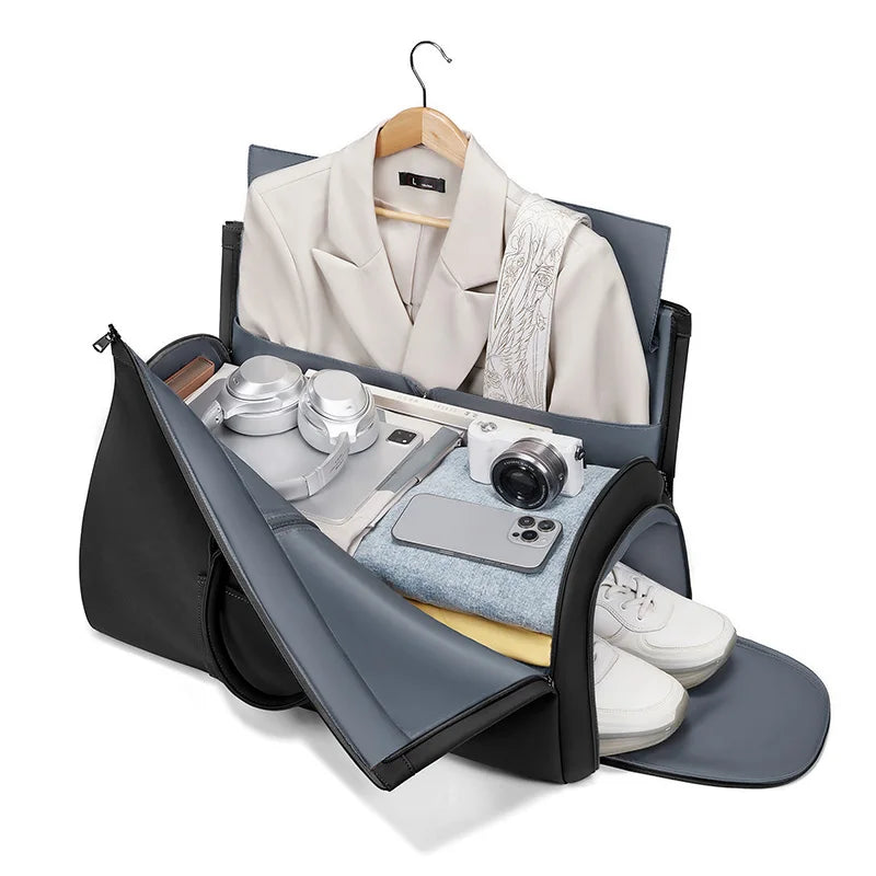 Black and gray travel bag with clothes and items on a white background
