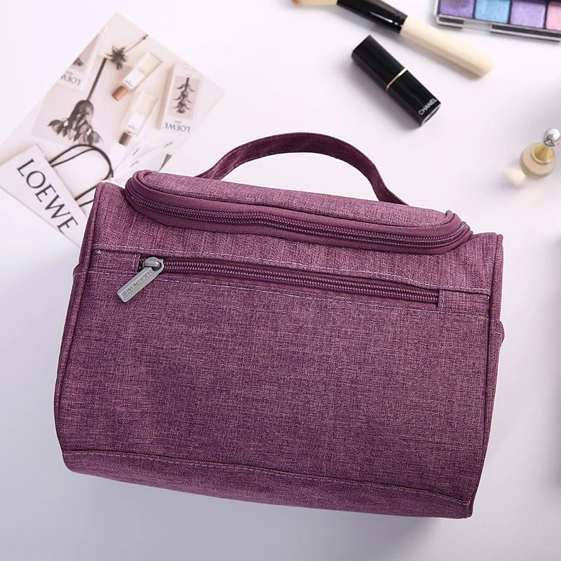 Purple toiletry bag with makeup items on a light background