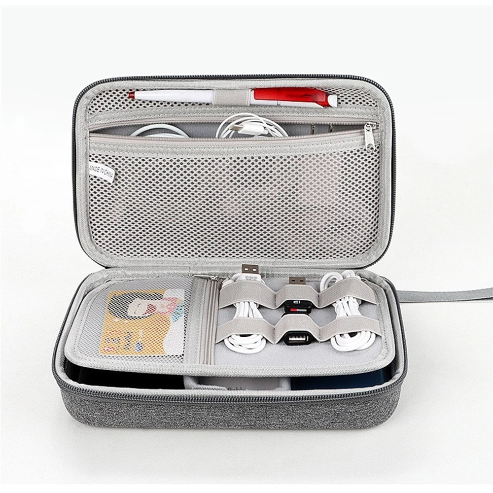 Gray travel case with electronic accessories on a white background