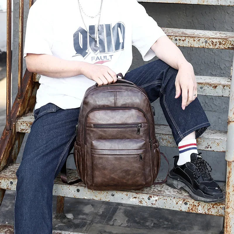 Person sitting on a bench with a brown leather backpack