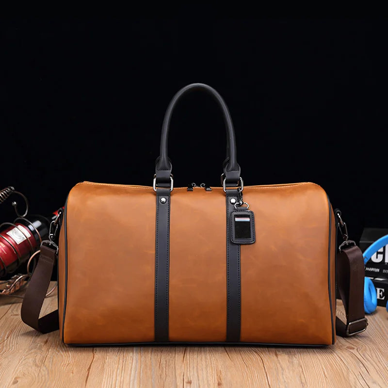 Brown leather duffel bag with black straps on a wooden surface