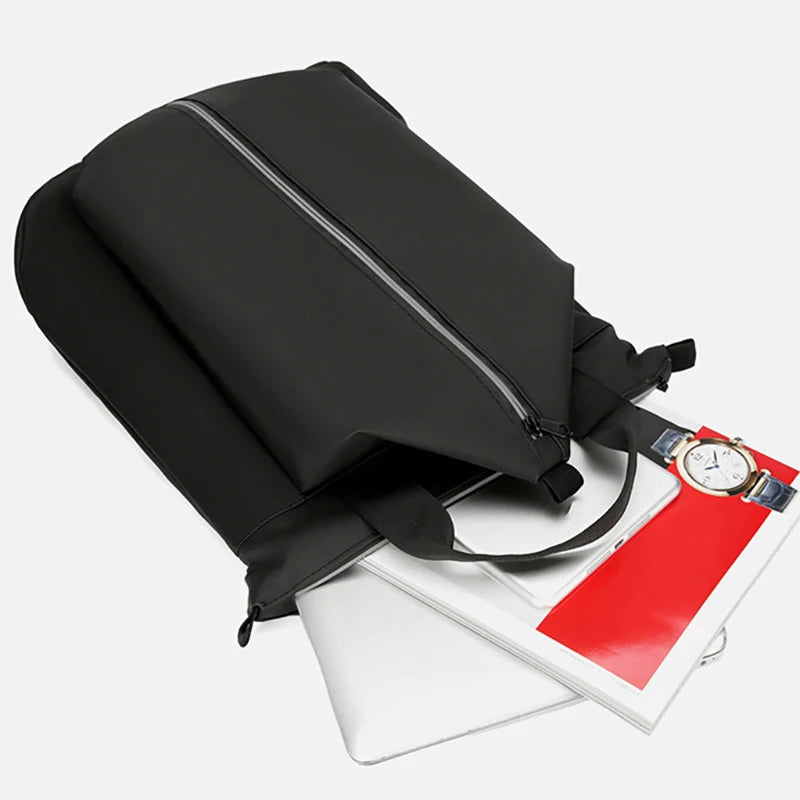 Black backpack with a watch and notebook on a white background