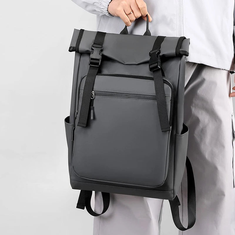 Gray backpack held by a person against a light gray background