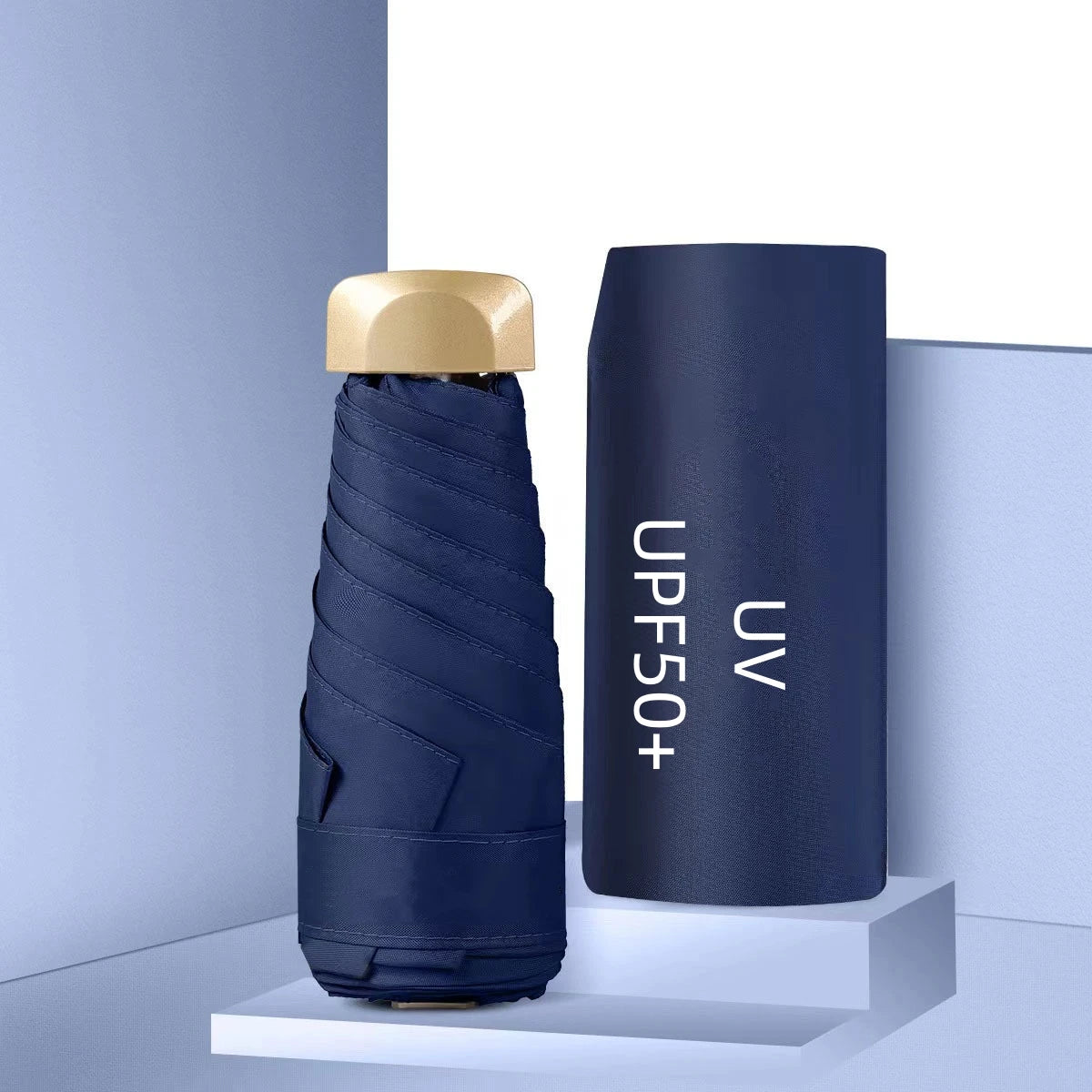 Foldable navy blue umbrella with gold handle on a light blue background