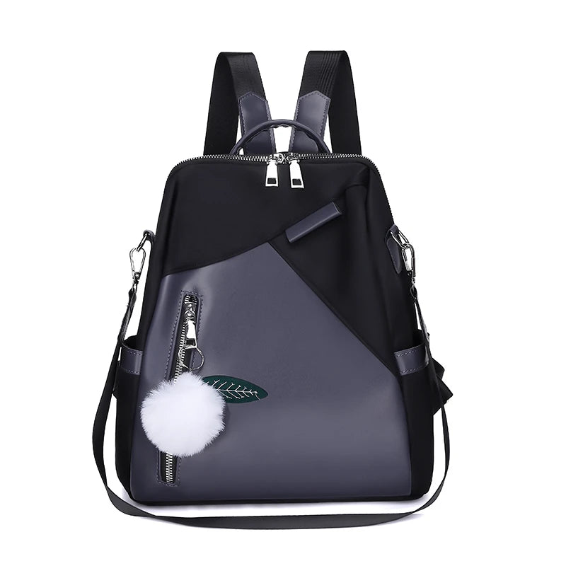 Black and gray backpack with a pom-pom and zipper detail on a white background