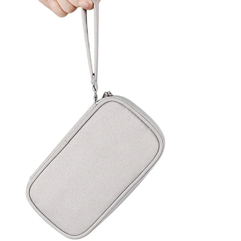 Gray pouch with a strap held by a hand on a white background