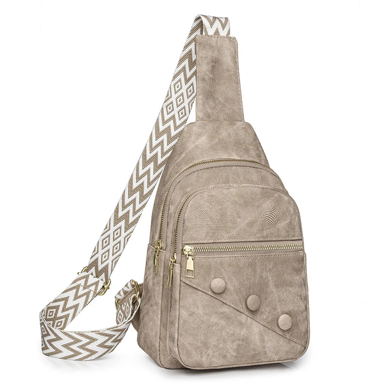 Beige suede sling bag with a patterned strap on a white background