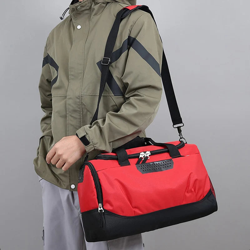 Person wearing a green jacket holding a red and black duffel bag against a gray background