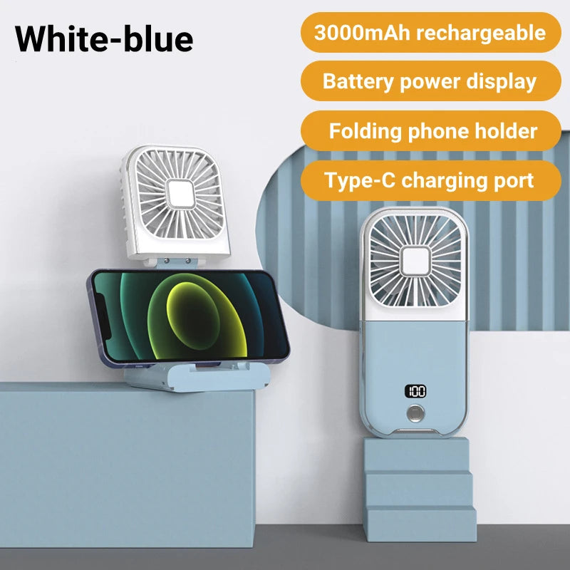 White-blue portable fan with phone holder and charging port on a light gray background