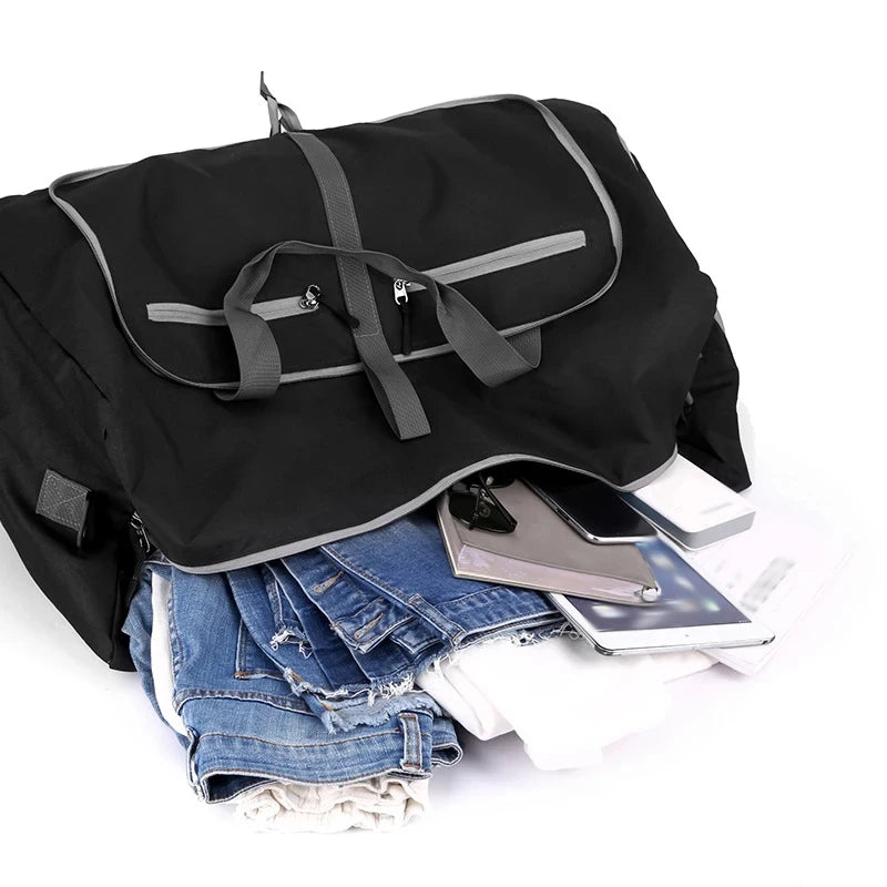 Black duffel bag with clothes and electronic devices on a white background