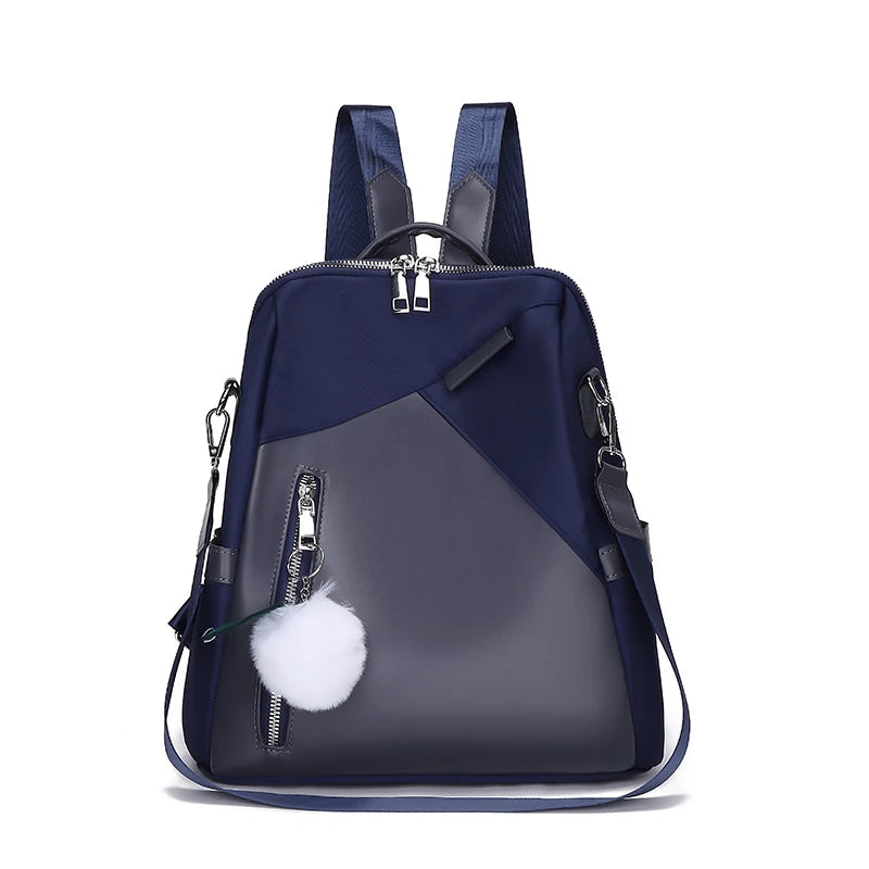 Navy and gray backpack with a white pom-pom on a white background