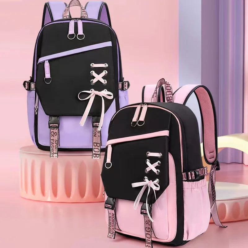 Two backpacks, one black with pink accents and the other black with purple accents, on a pink background.