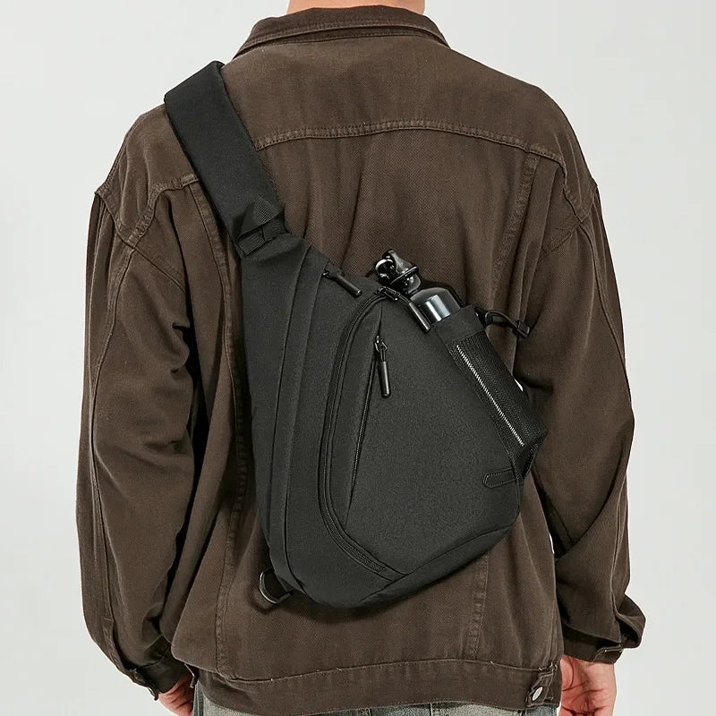 Person wearing a black sling bag over one shoulder on a plain background