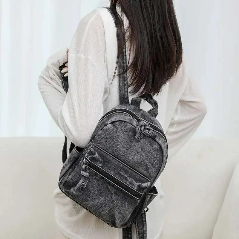 Person wearing a gray backpack against a white background