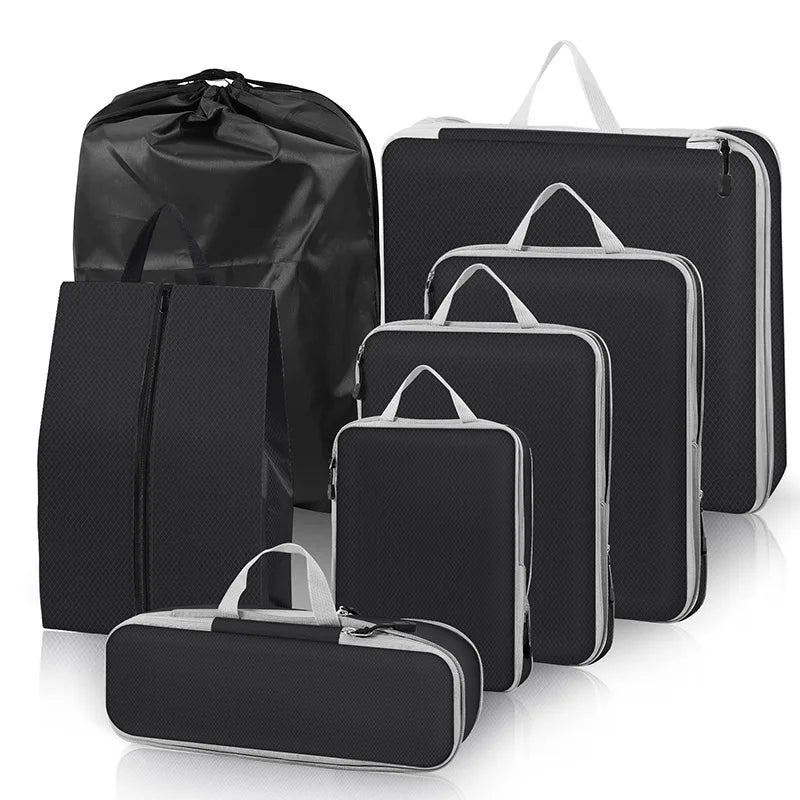 Set of black travel packing cubes with varying sizes on a white background