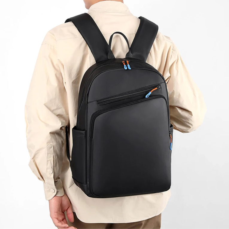 Person wearing a black backpack on a plain background