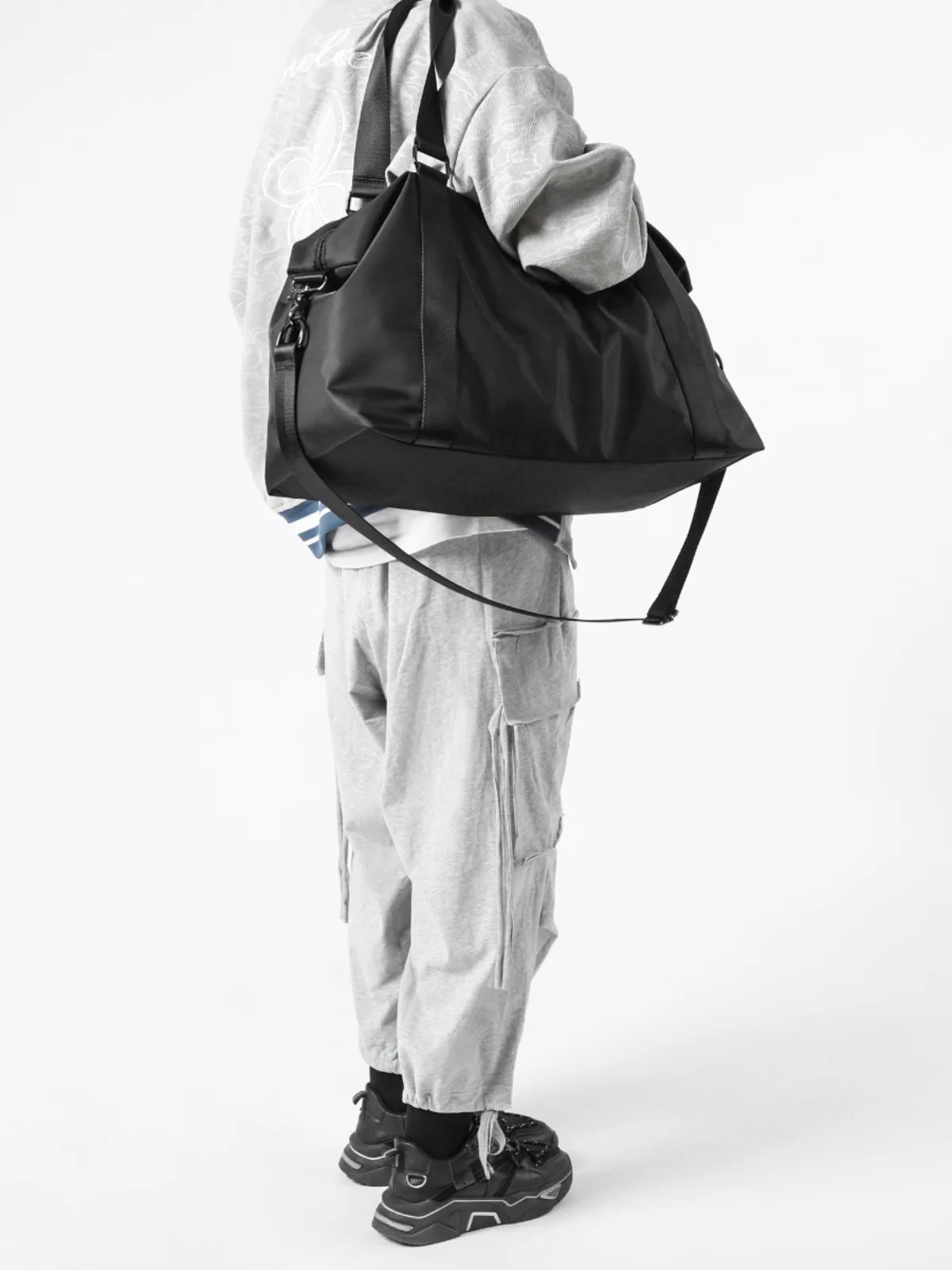 Person wearing a black backpack and gray outfit on a white background