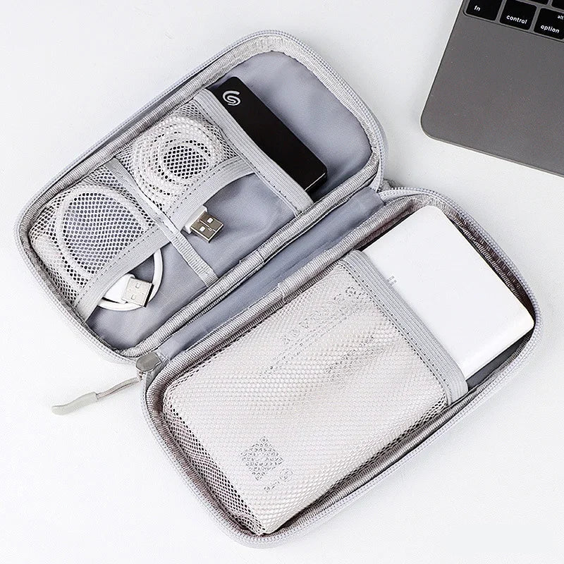Open travel organizer with electronic devices on a white background