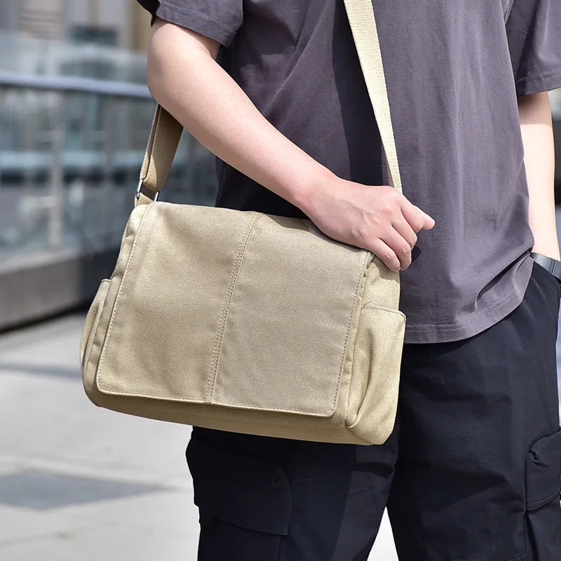 Person holding a beige shoulder bag outdoors