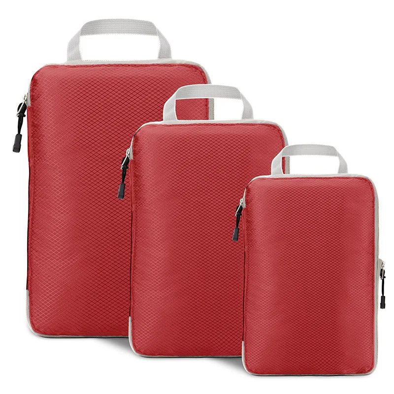 Three red packing cubes with white handles on a white background