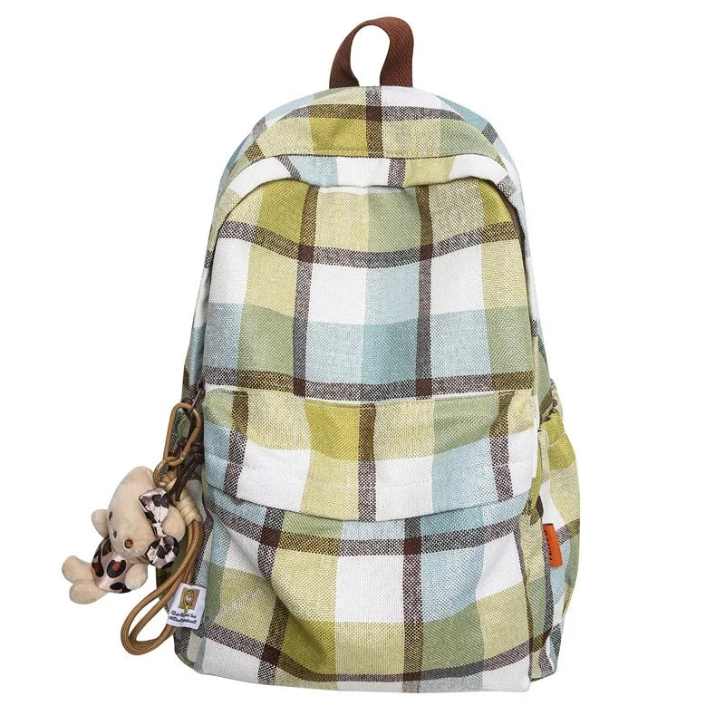 Plaid patterned backpack with a teddy bear charm on a white background