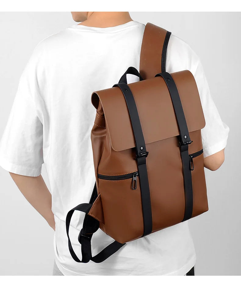 Brown backpack with black straps worn by a person on a white background
