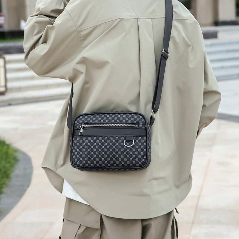 Person wearing a beige coat with a black checkered bag on a city street.