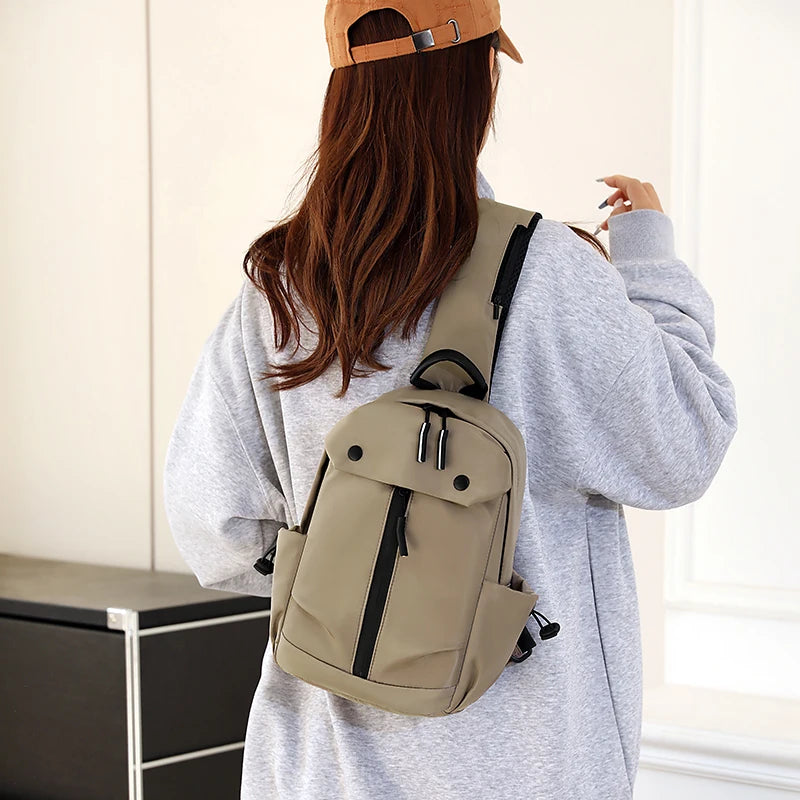Person wearing a beige backpack and brown cap indoors