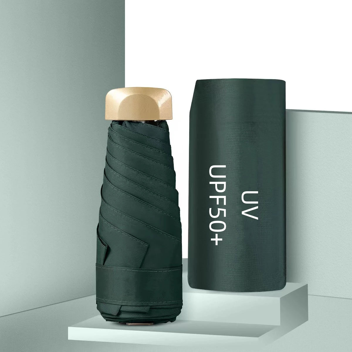 Foldable umbrella with gold cap and UV protection label on a gray background
