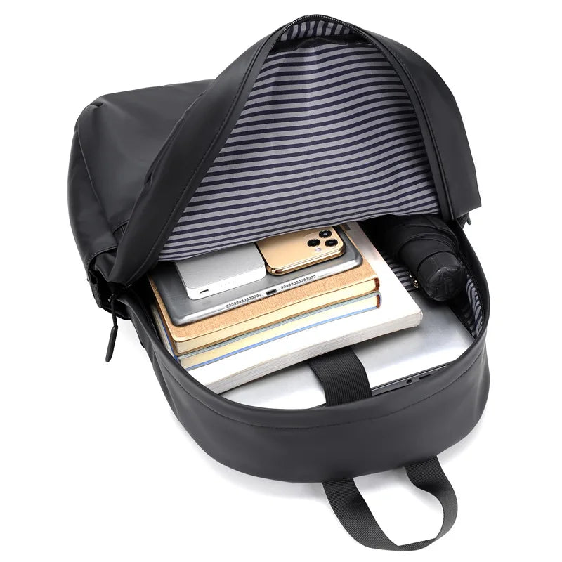 Interior view of a spacious black backpack showing organized essentials like a laptop and notebooks.