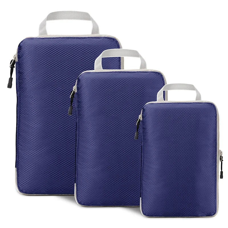 Three blue packing cubes with white handles on a white background