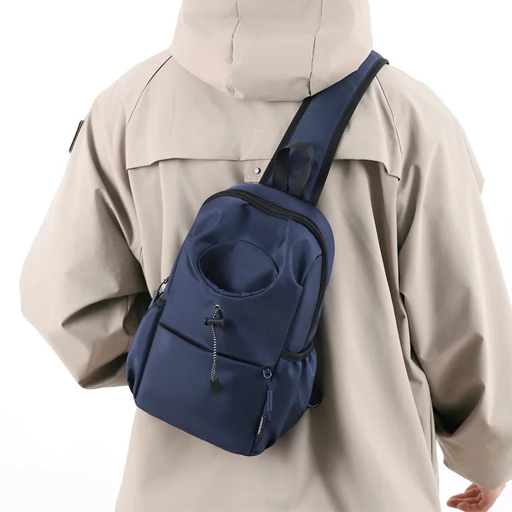 Person wearing a beige jacket with a navy blue sling bag on a white background
