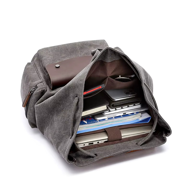 Gray backpack with compartments filled with items on a white background