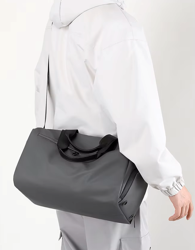 Person wearing a gray shoulder bag on a plain background