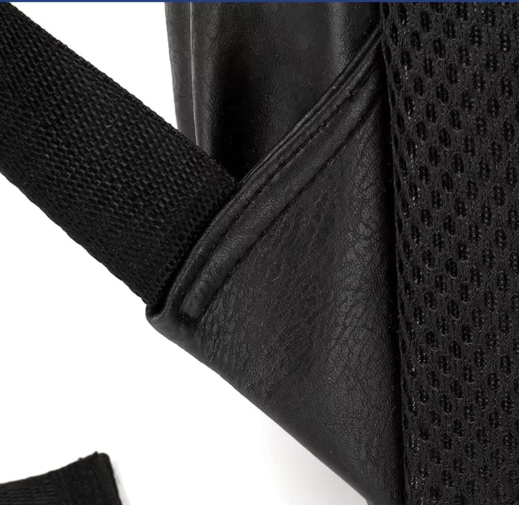Close-up of a black leather bag with a textured strap on a white background