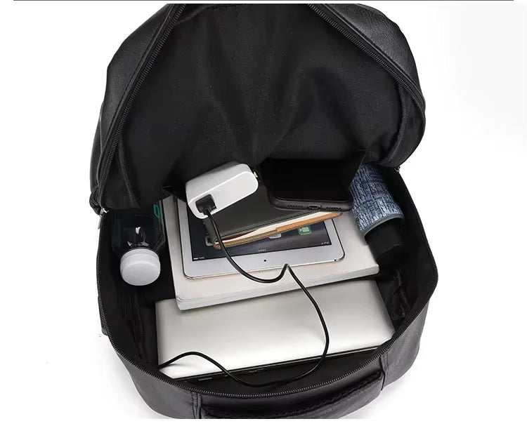 Black backpack with electronic devices inside on a white background