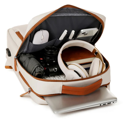 Open backpack with laptop, camera, and other items on a white background