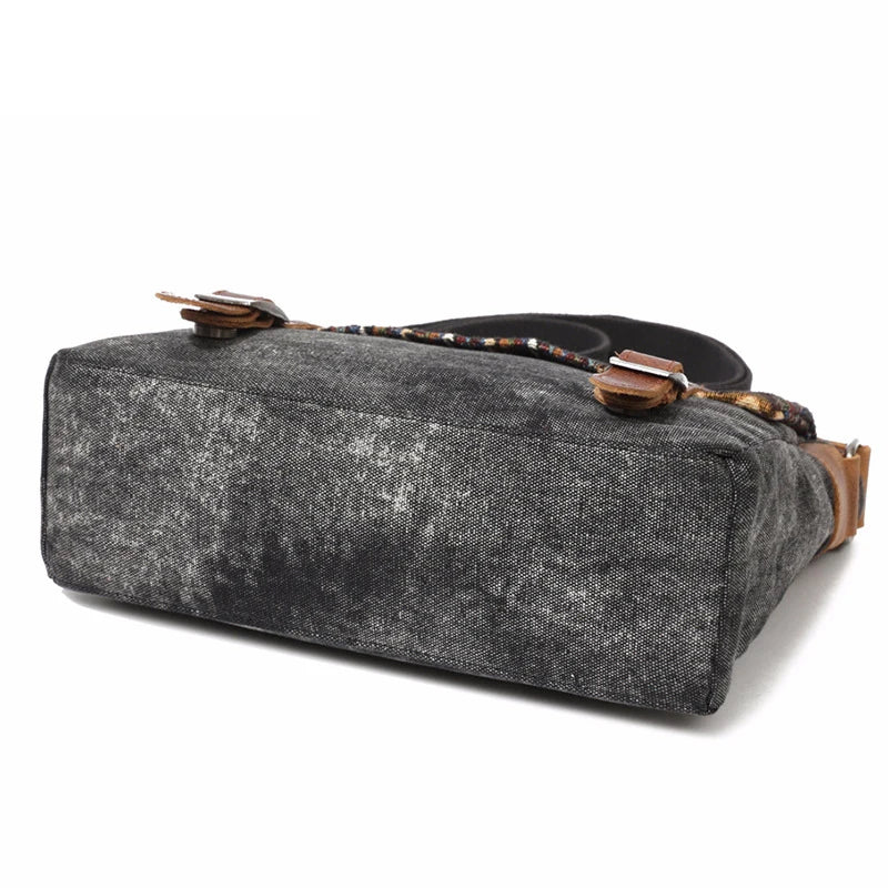 Gray textured bag with brown leather strap on a white background