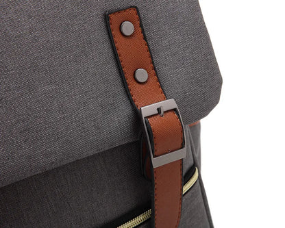 Gray backpack with a brown leather strap and metal buckle on a white background