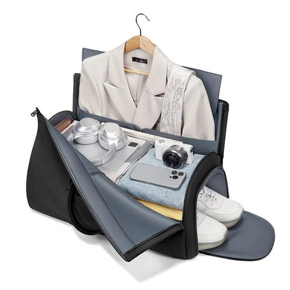 Black and gray travel bag with clothes and items on a white background