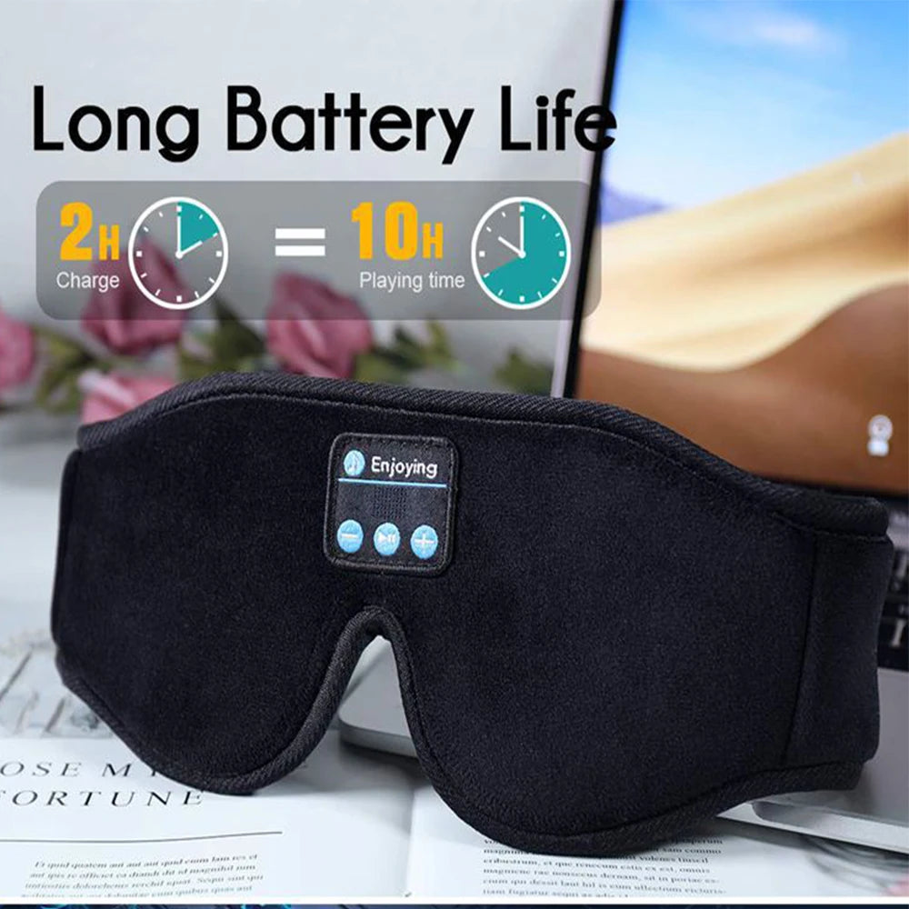 Black sleep mask with Bluetooth control panel on a table, showing battery life text and graphics.
