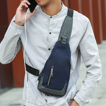 Person wearing a navy blue sling bag, listening to music with earphones, against a blurred background.