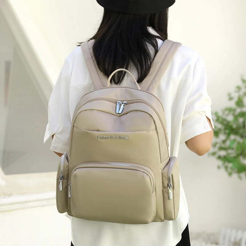 Person wearing a beige backpack with a blurred background