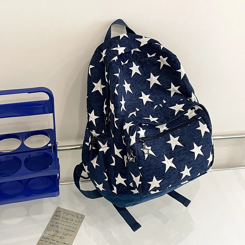 Navy blue backpack with white star pattern on a white surface