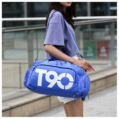 Person holding a blue duffel bag with 'T90' logo outdoors.